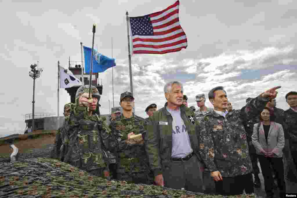 South Korean Defense Minister Kim Kwan-jin (R) points out a location in North Korea to U.S. Secretary of Defense Chuck Hagel, from Observation Point Ouellette during a tour of the Demilitarized Zone (DMZ), South Korea. 