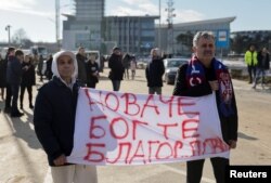 Fans of Serbian tennis player Novak Djokovic wait for his arrival at Nikola Tesla Airport, after the Australian Federal Court upheld a government decision to cancel his visa to play in the Australian Open, in Belgrade, Serbia, Jan. 17, 2022. Banner reads 'Novak God bless you.'