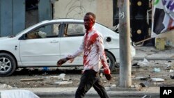 An injured civilian walks away from the scene after being wounded in a bomb blast near the Sahafi hotel in the capital Mogadishu, Somalia, Nov. 9, 2018. 