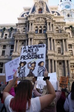 Manifestantes en la Marcha de las Mujeres en Filadelfia, el sábado 17 de octubre de 2020 levantan un cartel que dice "El lugar de una mujer es la resistencia". La marcha fue parte de una protesta nacional.