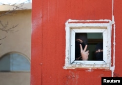 Pro-settlement activists are seen through the window of a house during the second day of an operation by Israeli forces to evict the illegal outpost of Amona in the occupied West Bank Feb. 2, 2017.