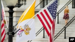 La bandera del Vaticano junto a banderas de Estados Unidos cerca de la Casa Blanca, en Washington.
