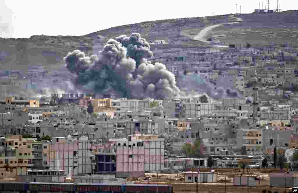 Smoke rises above the Syrian town of Kobani after an airstrike by the U.S.-led coalition, seen from a hilltop on the outskirts of Suruc, Turkey, near the Turkey-Syria border, Oct. 26, 2014. 