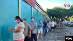 Varias personas hacen fila para votar en las elecciones generales de Nicaragua, el domingo 7 de noviembre del 2021, en Managua. Voz de América.