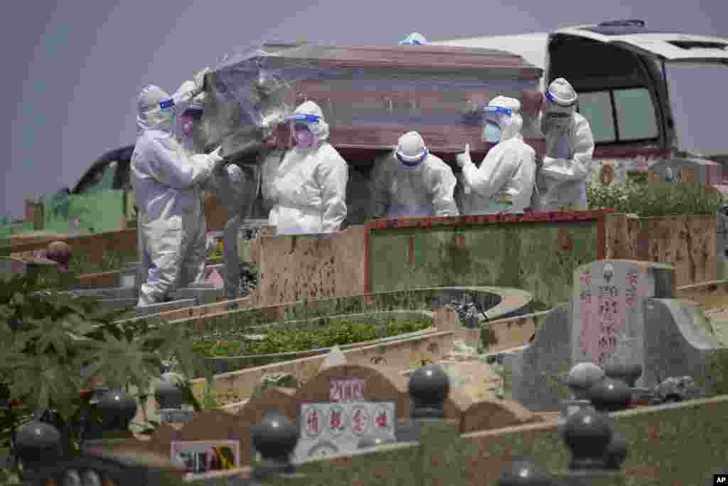 Health workers wearing Personal Protective Equipment (PPE) carry a coffin during a funeral for a COVID-19 victim in Klang, Malaysia.