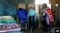 A Masai woman walks towards ballot boxes to cast her vote in a general election in Kajiado West, some 60 kilometers (37 miles) from Nairobi, Kenya, Monday, March 4, 2013. 