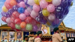 Scouts carry balloons during the 20th anniversary of Cambodian King Norodom Sihamoni&#39;s coronation in front of the Royal Palace in Phnom Penh.