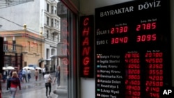 People walk past a currency exchange office in Istanbul, Turkey, June 8, 2015. The Turkish currency dropped to a record low against the dollar over the political uncertainty, trading at 2.8 lira against the dollar. 
