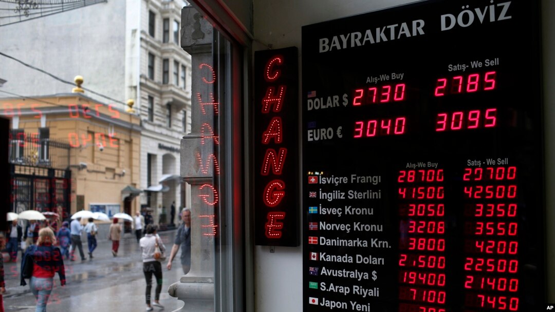 People walk past a currency exchange office in Istanbul, Turkey, June 8, 2015. The Turkish currency dropped to a record low against the dollar over the political uncertainty, trading at 2.8 lira against the dollar. 
