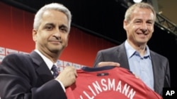 Juergen Klinsmann, of Germany, right, smiles after being introduced as the head coach of the U.S. men's soccer team by U.S. Soccer President Sunil Gulati, left, at a news conference in New York, Monday, Aug. 1, 2011.