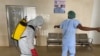 A health worker wearing protective equipment, disinfects a member of medical staff amid the spread of the coronavirus disease (COVID-19), at an hospital in Douala, Cameroon, April 27, 2020.