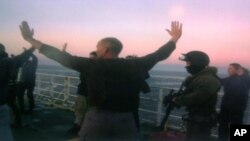 Gambar yang dirilis oleh Greenpeace menunjukkan pasukan pengawal pantai Rusia menaiki kapal Greenpeace 'Arctic Sunrise' dan menahan para penumpangnya (foto: dok). 