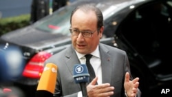 French President Francois Hollande speaks with the media as he arrives for an EU summit at the EU Council building in Brussels, Oct. 15, 2015.