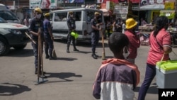 Des policiers patrouillent et recherchent d'éventuels contrevenants au port du masque obligatoire, dans le centre-ville d'Antananarivo le 27 avril 2020.