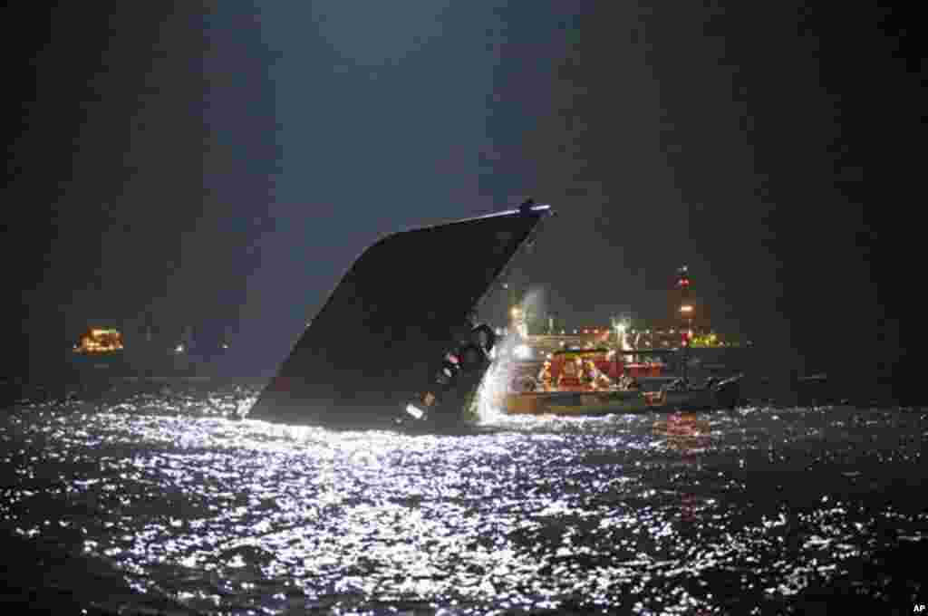 Rescuers check on a half submerged boat after it collided Monday night near Lamma Island, off the southwestern coast of Hong Kong Island, October 2, 2012. 