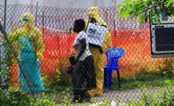 A woman and her child arrive for an Ebola-related investigation at the health facility at the Bwera hospital near the border with the Democratic Republic of Congo in Bwera, Uganda, June 14, 2019.