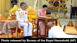 Thailand's King Maha Vajiralongkorn Bodindradebayavarangkun, left, sits with Queen Suthida Vajiralongkorn Na Ayudhya as they sign their marriage certificates at Ampornsan Throne Hall in Bangkok, May 1, 2019.