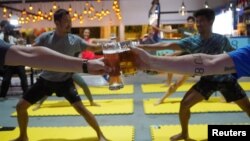 People participate in a beer yoga session, as the country eases the coronavirus disease (COVID-19) restrictions, at a craft brewery in Phnom Penh, Cambodia January 19, 2021. (REUTERS/Cindy Liu)