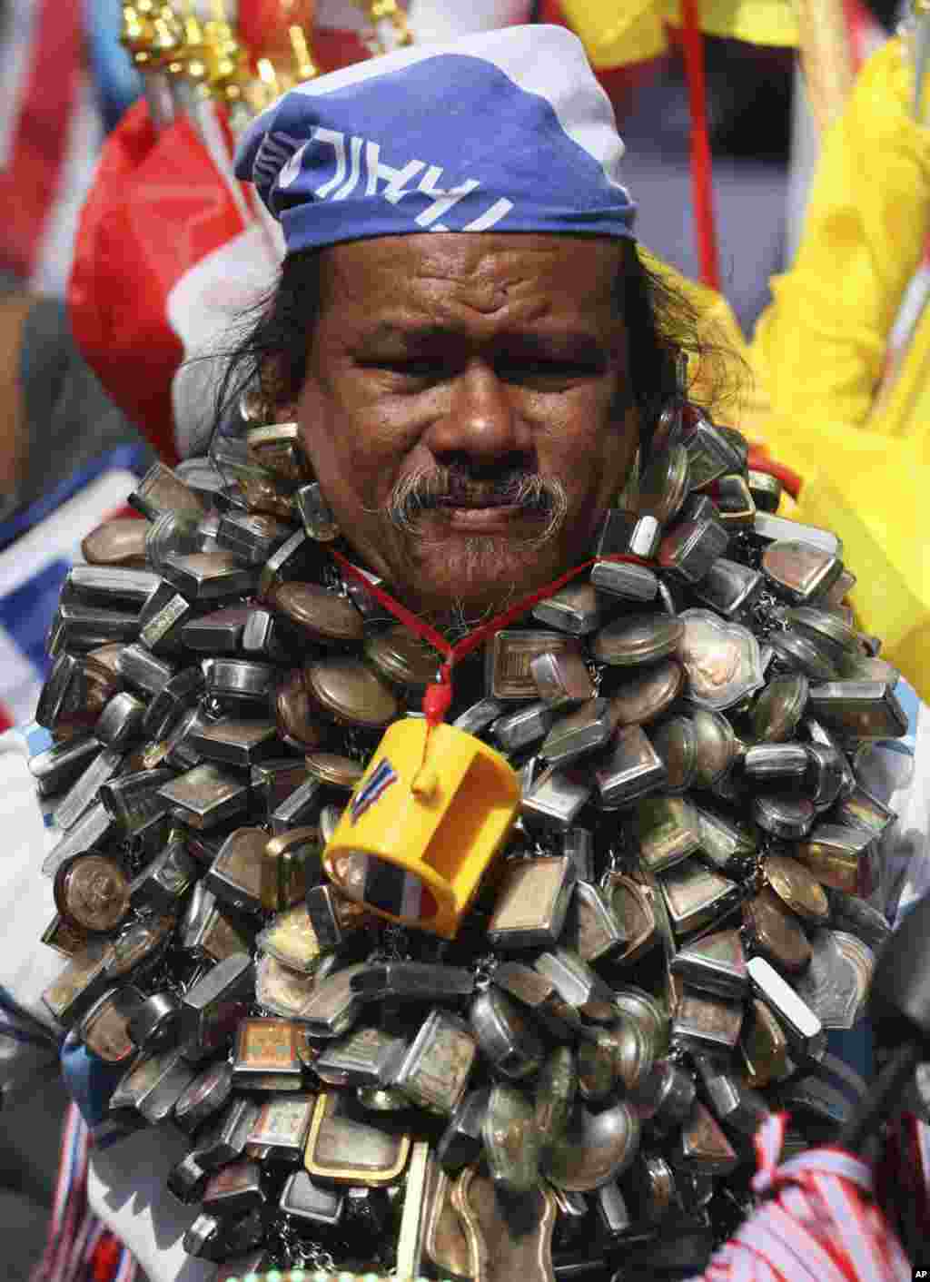 An anti-government protester has Buddhist amulets around his neck as he takes part in a rally, in Bangkok, Thailand. 