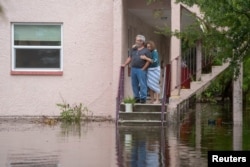 Ken and Tina Kruse stand next to their apartment after the area flooded from Hurricane Idalia in Tarpon Springs, Florida, U.S. August 30, 2023. (Greg Lovett/USA Today Network via REUTERS)