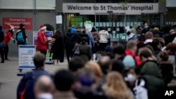 부스터샷을 맞으려는 영국 런던 시민들이 지난달 세인트 토머스 병원 입구에 줄지어 서있다. (자료 사진)