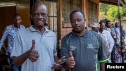 Voters show their inked fingers to the media after casting their ballots at polling centre during the presidential election in Kigali, Rwanda ,July 15, 2024.