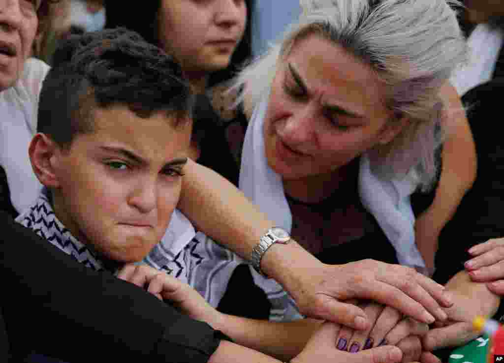 Omar, left, and his mother Lara, the son and the wife of of Alaa Abu Fakher, who was killed by a Lebanese soldier in Tuesday night protests south of Beirut, attend his funeral, in Choueifat neighborhood.