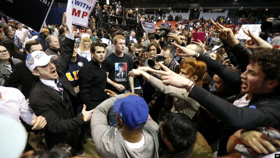 Para pendukung Donald Trump (kiri) saling dorong dengan para demonstran anti Trump di kota Chicago, Jumat malam (11/3).