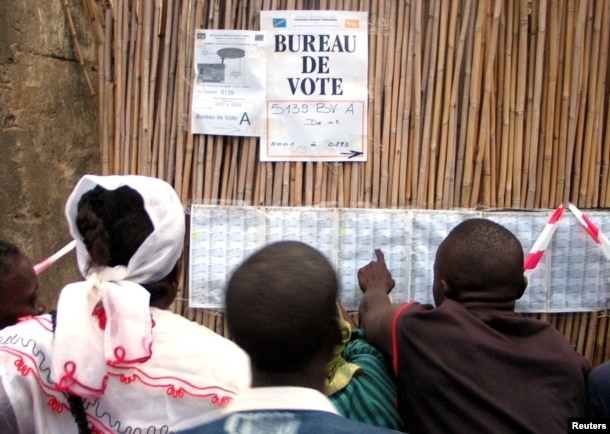 FILE - Congolese voters check their names on a list before casting their ballots in Bunia, eastern Democratic Republic of Congo, July 30, 2006.