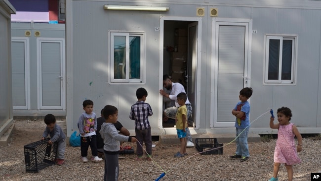 Un grupo de niños juega en el campamento de refugiados de Ritsona, a unos 86 kilómetros (53 millas) al norte de Atenas, en el Día Mundial de los Refugiados, el miércoles 20 de junio de 2018.