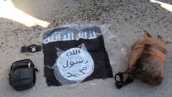 This photo provided by the Kurdish-led Syrian Democratic Forces shows a flag and bags of Islamic State group fighters arrested by the Kurdish-led Syrian Democratic Forces after they attacked Gweiran Prison, in Hassakeh, northeast Syria, Jan. 21, 2022.