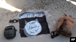 This photo provided by the Kurdish-led Syrian Democratic Forces shows a flag and bags of Islamic State group fighters arrested by the Kurdish-led Syrian Democratic Forces after they attacked Gweiran Prison, in Hassakeh, northeast Syria, Jan. 21, 2022.