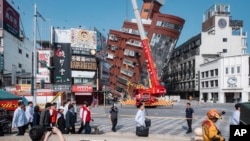 2024年4月3日星期三，台湾候任总统兼副总统赖清德（中左红衣）在台湾东部花莲参观地震后部分倒塌的建筑物现场。