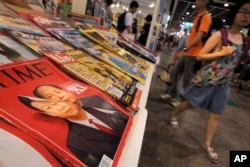 FILE - A copy of Time Magazine featuring portraits of Chinese leader Xi Jinping and former leader Mao Zedong on its cover is seen on display at an annual book fair in Hong Kong, July 20, 2016.