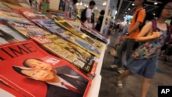 FILE - A copy of Time Magazine featuring portraits of Chinese leader Xi Jinping and former leader Mao Zedong on its cover is seen on display at an annual book fair in Hong Kong, July 20, 2016.
