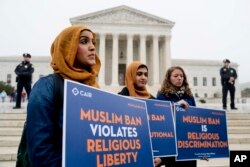 Desde la izquierda, Zainab Chaudry, Zainab Arain y Megan Fair, del Consejo de Relaciones Islámico-Estadounidenses, protestan fuera de la Corte Suprema, mientras la corte escucha argumentos sobre si la prohibición del presidente Donald Trump a los viajeros. Abril 25 de 2018.