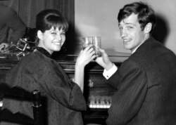 FILE - French actor Jean-Paul Belmondo and Italian actress Claudia Cardinale attend a cocktail party in the Foreign Press Association in Rome, Nov. 3, 1960.