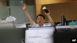 A currency trader gestures at the foreign exchange dealing room of the KEB Hana Bank headquarters in Seoul, South Korea, July 9, 2020.