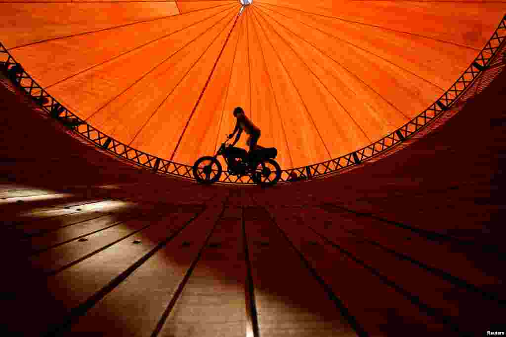 A stuntman rides a motorcycle inside the &quot;Well of Death&quot; attraction during a fair in Bhaktapur, Nepal.