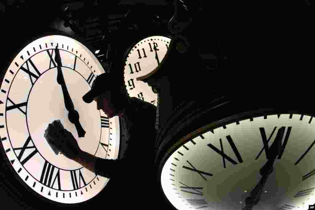 Dave LeMote wipes down a post clock at Electric Time Company, Inc. in Medfield, Massachusetts, Mar. 7, 2014. Most Americans will set their clocks 60 minutes forward before heading to bed Saturday night, but daylight saving time officially starts Sunday at 2 a.m. local time (0700GMT).