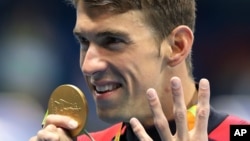 ນັກລອຍນ້ຳ ສຫລ ທ້າວ Michael Phelps ສະຫຼອງຫຼຽນຄຳ ໃນການລອຍນ້ຳທ່າປະສົມ medley 200 ແມັດ. (11 ສິງຫາ 2016)
