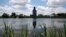 FILE - A grain elevator is reflected in a wetland area at Holmquist, S.D., June 18, 2019. 