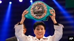 FILE - Hideko Hakamada, sister of Iwao Hakamada whose death sentence was reversed, shows off a honorary boxing champion belt presented to her brother by the World Boxing Council in Tokyo, April 6, 2014.