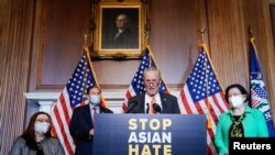 Senate Majority Leader Chuck Schumer (D-NY) is joined by fellow Democrats as he speaks at a news conference after the Senate passed the COVID-19 Hate Crimes Act on Capitol Hill in Washington, April 22, 2021. 