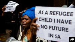 FILE - A woman protests with others outside the U.N. refugee agency offices in Cape Town, South Africa, Oct. 30, 2019.