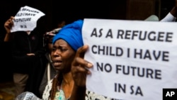 FILE - A woman protests with others outside the U.N. refugee agency offices in Cape Town, South Africa, Oct. 30, 2019.