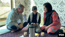 Afghan refugee Ahmad Zahir Sultani sits with his wife and daughter in Islamabad, Pakistan. (Muska Safi/VOA)