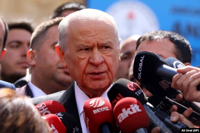 FILE - Devlet Bahceli, chairman of the Nationalist Movement Party or MHP, talks to the media after casts his ballot at a polling station in Ankara, Turkey, March 31, 2019.