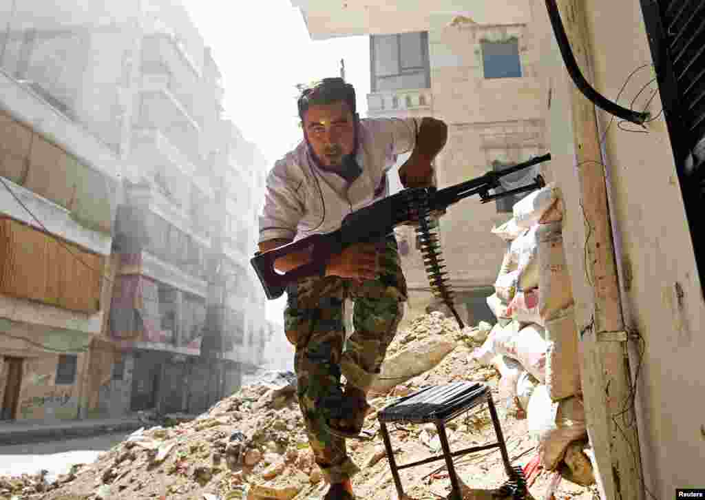 August 7: A Free Syrian Army fighter takes cover during clashes with the Syrian Army in central Aleppo, Syria.