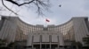 FILE - The national flag flies in front of China's central bank in Beijing, Jan. 20, 2022. Ratings agency Moody's cut its outlook on China's government credit ratings to negative from stable, Dec. 5, 2023.